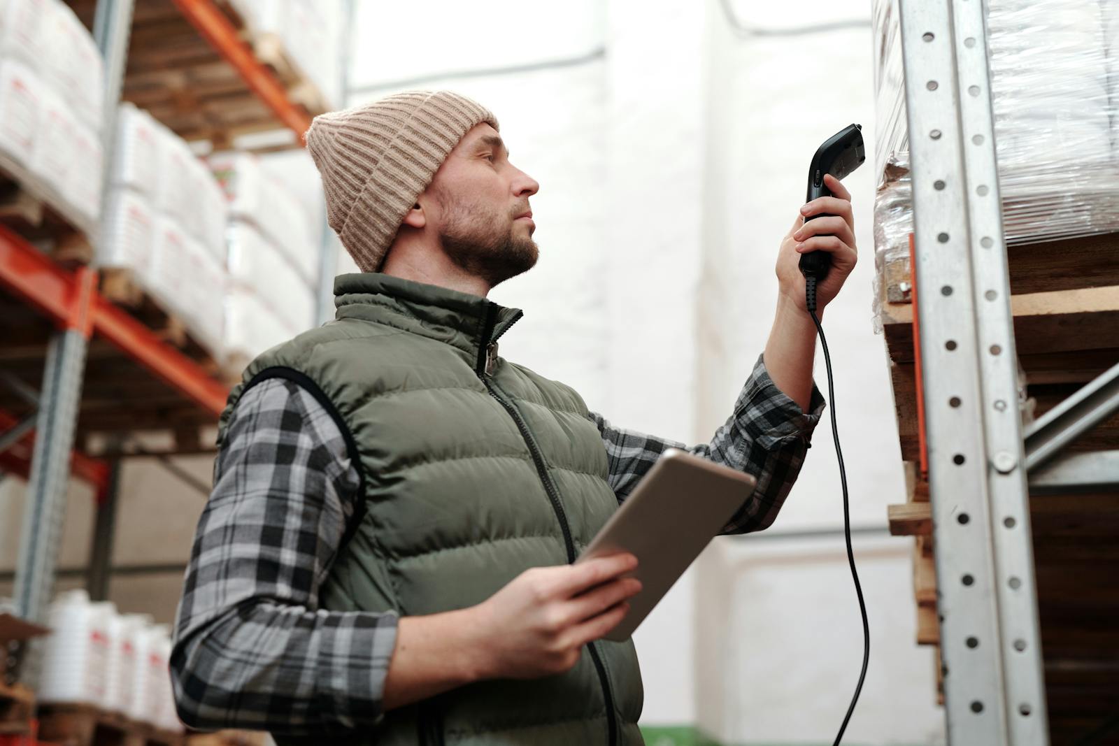 Amazon FBA prep center operator scanning a removed inventory carton with a handheld barcode scanner